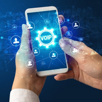 voip services best residential voip providers home voip 2020 man holding smartphone voip on display blue background